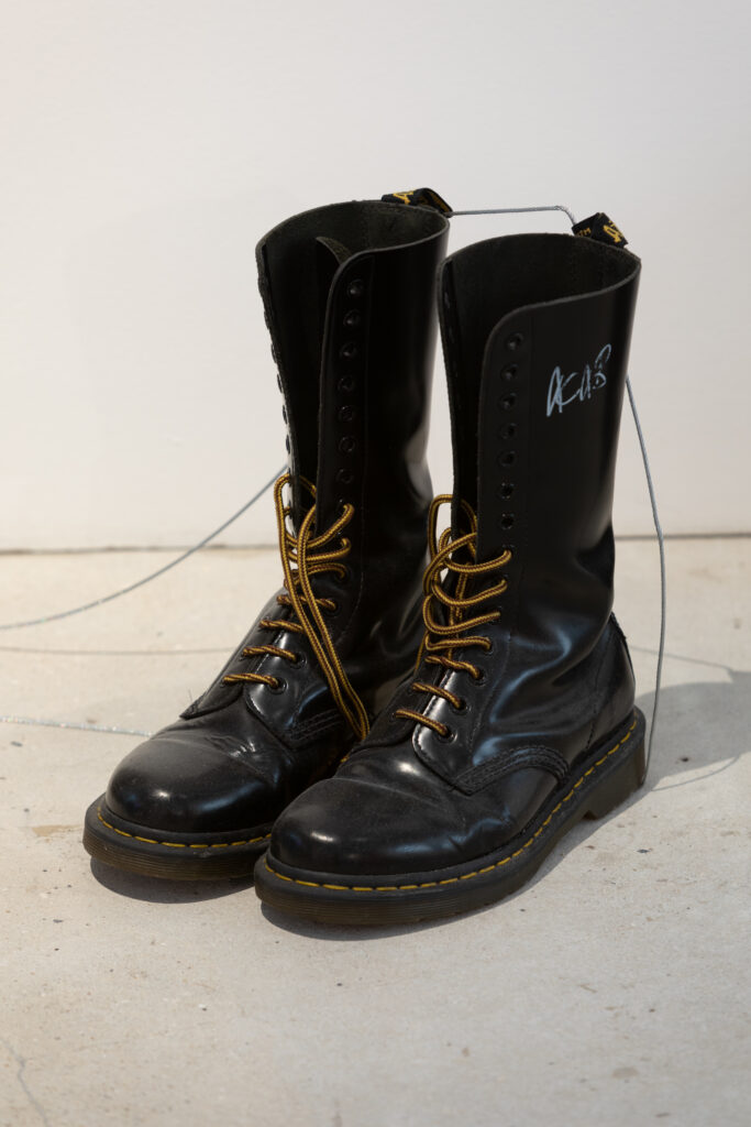 Tall DM boots, half laced, with ACAB written on the side.
Rebel Dykes - Section from installation of Muddy Puddle, 2020 - Rene Matić